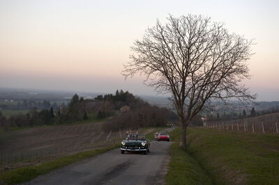 Cars on Tuscan roads at sunset